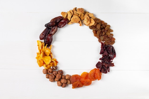 Un Ensemble De Baies Séchées, De Fruits Et De Noix Sous La Forme D'une Couronne (noisette, Citrouille, Cerise, Abricot, Pomme, Dattes)