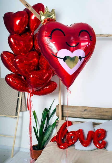 Ensemble de ballons à air en gel rose et rouge pour la fête de la Saint-Valentin ou la douche de bébé près du lit.