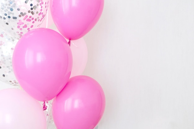 Un ensemble de ballons à air roses et transparents avec un espace de copie de confettis argentés pour votre texte des couleurs pastel tendres pour une fête entre filles