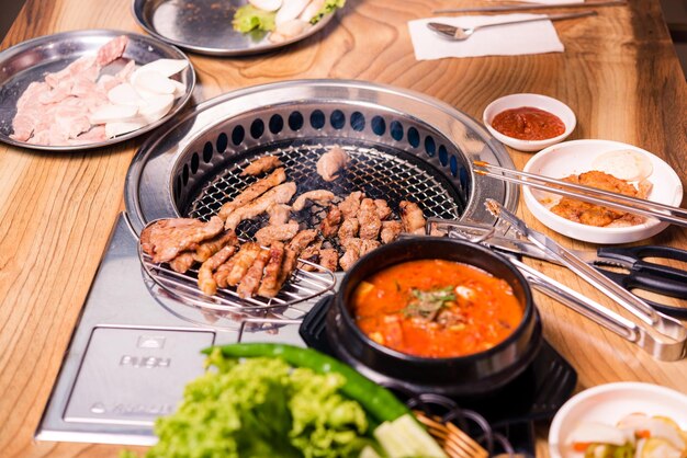 Ensemble de barbecue coréen boeuf pour grill sur cuisinière servir avec table en bois de légumes et de soupe