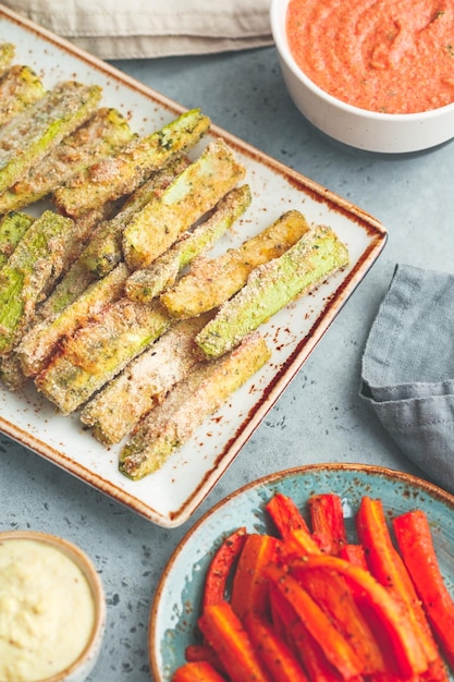 Ensemble de bâtonnets de légumes de saison cuits au four avec sauce et houmous Aliments sains végétariens