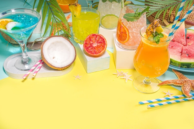 Photo ensemble de boissons d'été colorées. divers cocktails et boissons alcoolisés, dans différents verres, avec des fruits tropicaux