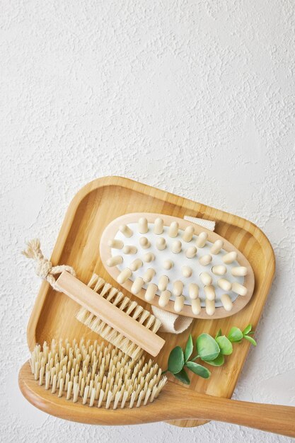 Un ensemble de brosses de bambou pour bain de massage sur un plateau en bois