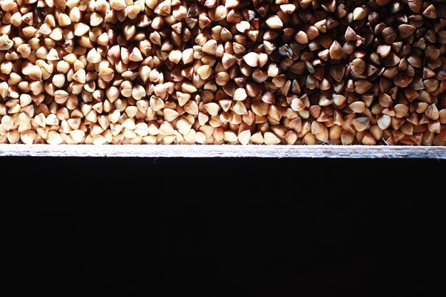 Un ensemble de céréales céréalières. Gruau de riz, de sarrasin et de millet dans un plateau en bois. Un ensemble de céréales d'épicerie. Importation de céréales.