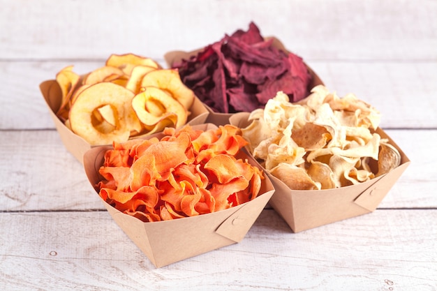 Photo ensemble de chips de légumes et de fruits dans des bols artisanaux. légumes et fruits secs. une collation bio pour toute la famille. concept d'alimentation saine