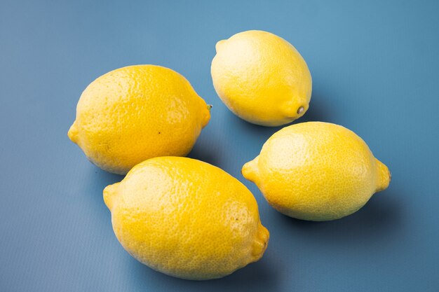 Ensemble de citrons mûrs jaunes, sur fond d'été texturé bleu