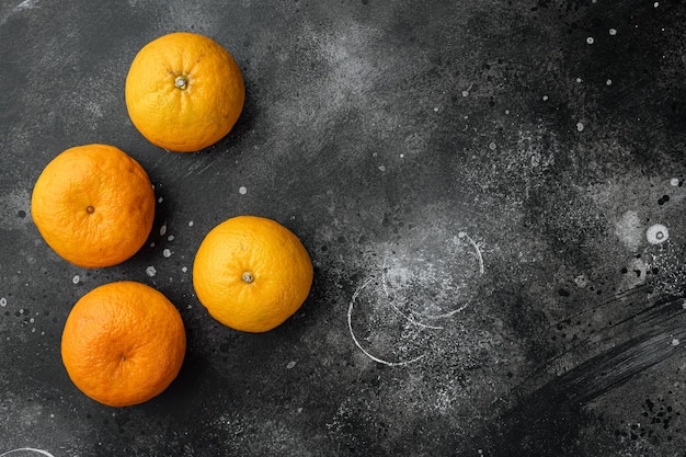 Ensemble de clémentine ou de mandarine biologique, sur fond de table en pierre noire noire, vue de dessus à plat, avec espace de copie pour le texte