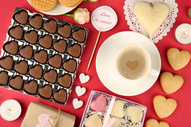 Ensemble de coeurs forme des biscuits et des bonbons sur la vue de dessus de table rouge