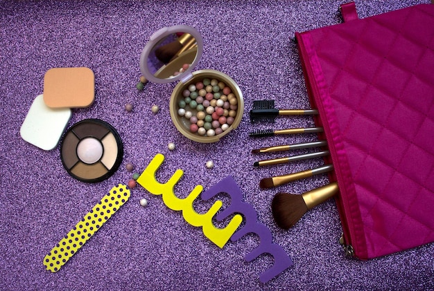 Ensemble de cosmétiques et accessoires sur fond violet brillant