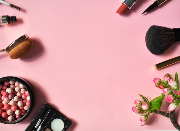 Un ensemble de cosmétiques décoratifs sur un mur rose. Top viev. Mise à plat.