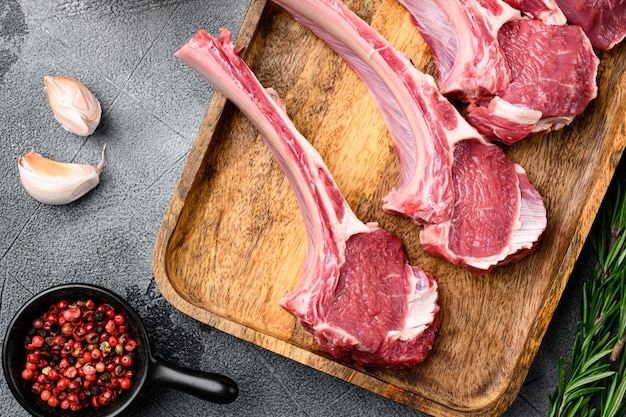 Ensemble de côtes de viande d'agneau fraîches, sur fond de table en pierre grise, vue de dessus à plat