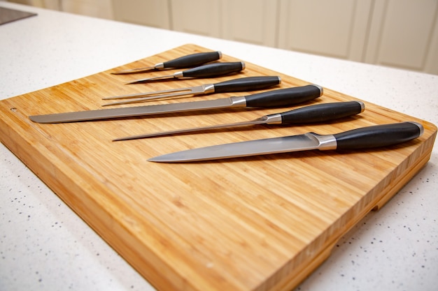 Ensemble de couteaux de cuisine sur une planche à découper en bois