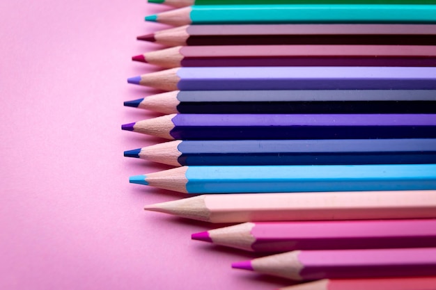 Ensemble de crayons colorés sur fond rose