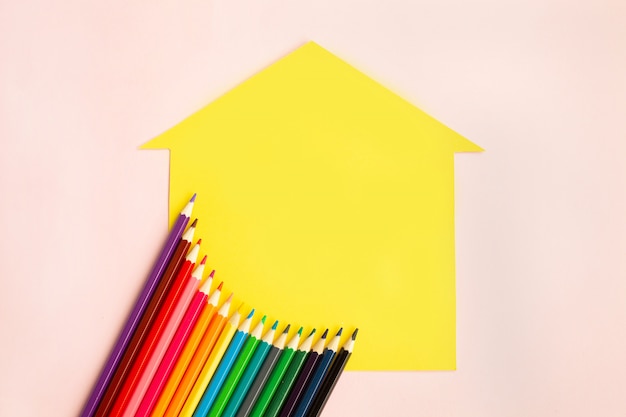 Ensemble de crayons de couleur sur une maison jaune