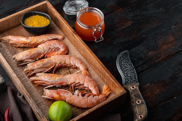 Ensemble de crevettes argentines rouges crues, dans une boîte en bois, sur la vieille table en bois sombre