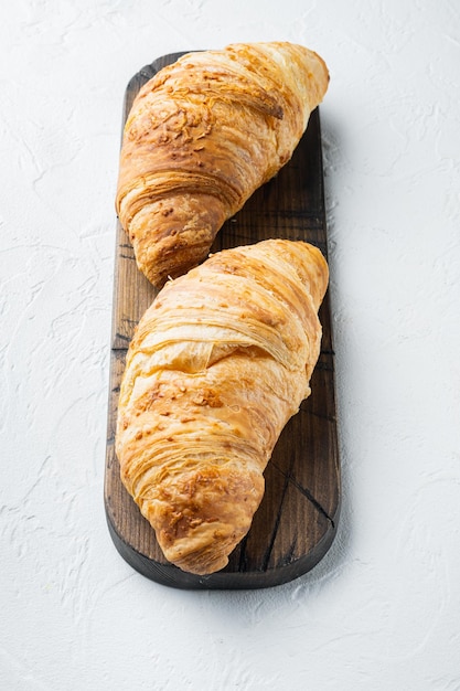 Ensemble de croissants frais croustillants, sur fond de pierre blanche