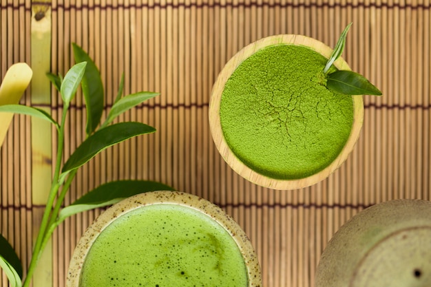 Ensemble de cuillère en bois avec un bol de poudre de matcha et un fouet de feuille de thé vert