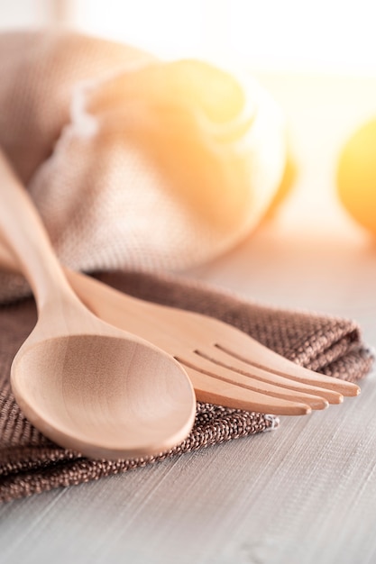 Photo ensemble de cuillère en bois et fourchette placée avec un tissu marron