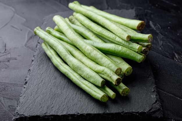 Ensemble de cuisine de haricots verts, sur planche de pierre, sur fond noir