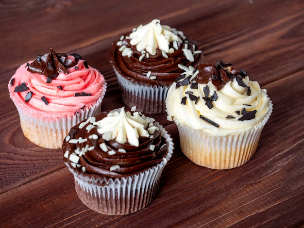 Un ensemble de cupcakes au chocolat délicieux et sucrés sur un fond en bois. Dessert riche en calories, mise au point sélective