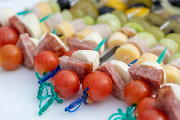 Ensemble de délicieux canapés gros plan De nombreux canapés avec du fromage à la saucisse et de la tomate rouge sur une assiette