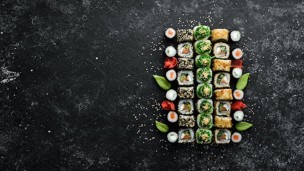 Ensemble de délicieux sushis et makis sur fond de pierre noire Cuisine japonaise Vue de dessus Espace libre pour votre texte