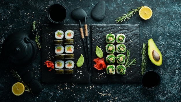 Ensemble de délicieux sushis et makis sur fond de pierre noire Cuisine japonaise Vue de dessus Espace libre pour votre texte