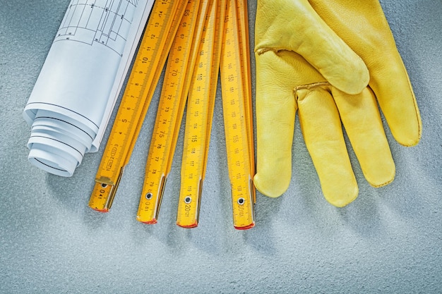 Ensemble de dessins de construction de gants de sécurité mètre en bois sur le concept de construction de fond en béton.