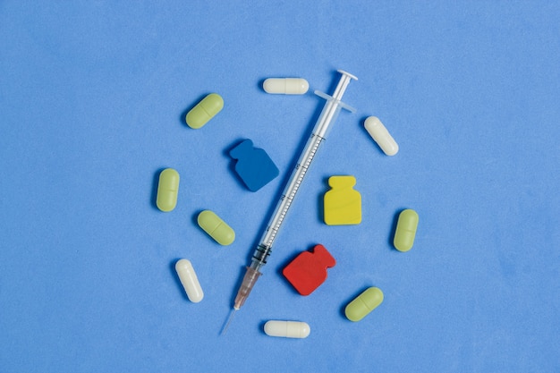Ensemble de divers comprimés, capsules, seringues sur bleu. Concept créatif de médecine.