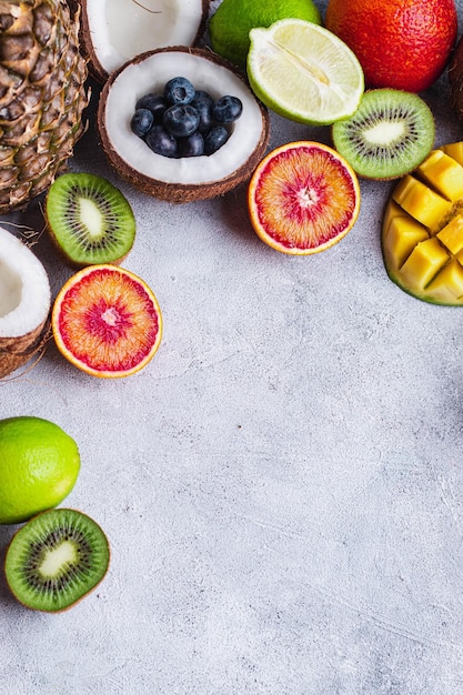 Ensemble de divers fruits rouge rouge orange noix de coco kivi mangue ananas citron vert myrtille fruits flatlay avec cadre alimentaire pour fond