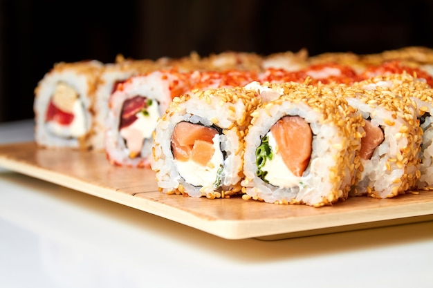 Ensemble de divers rouleaux de sushi sur une planche
