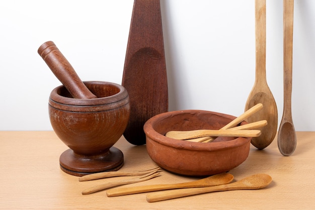 Ensemble de divers ustensiles de cuisine traditionnels en bois et un bol en argile