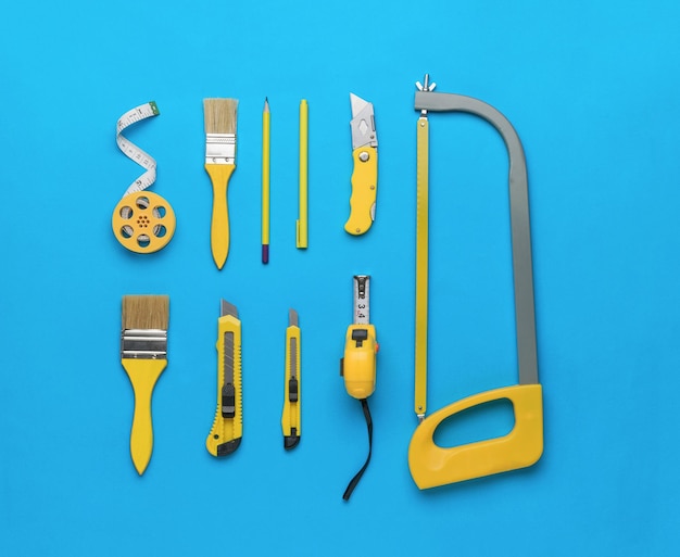 Un ensemble élégant d'outils à main jaunes sur fond bleu Le concept de réparation et de construction Mise à plat