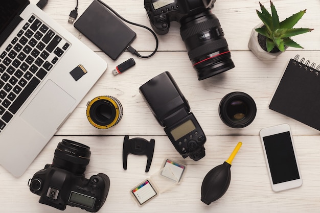Photo ensemble d'équipement photographique moderne sur une table en bois blanc, vue de dessus. outils professionnels de concepteur créatif, fond de milieu de travail de photographe