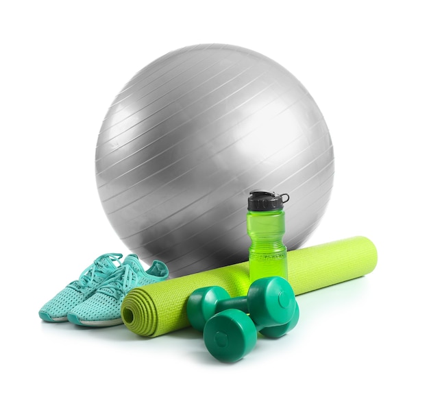 Ensemble d'équipements sportifs avec ballon de fitness, chaussures et bouteille d'eau sur fond blanc