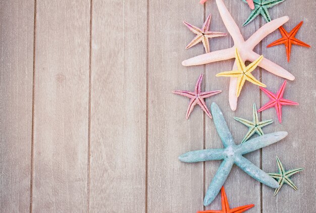 Ensemble d'étoiles de mer multicolores sur planche de bois comme bordure avec espace de copie, aux tons rétro