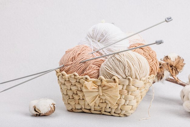 Un ensemble de fils pastel pour tricoter dans un panier Concept de crochet de passe-temps fait à la main Accessoires et outils d'artisanat spéciaux sur fond de béton de pierre claire espace de copie