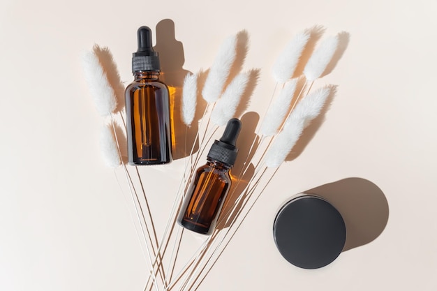 Ensemble de flacons cosmétiques en verre ambré sur fond beige flacon compte-gouttes et emballage de pot de crème Produits de beauté pour la peau conception d'emballages pour la routine quotidienne