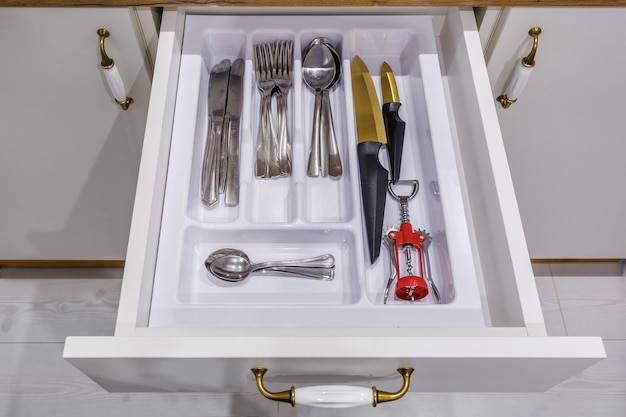 Ensemble de fourchettes et cuillères à couteaux sur l'étagère de l'armoire de cuisine