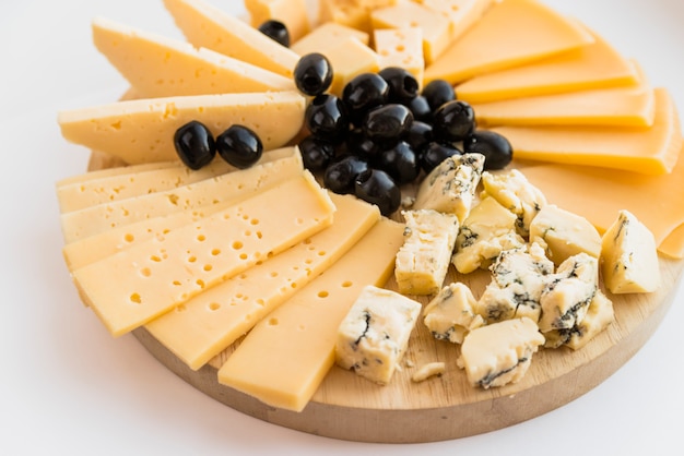 Photo ensemble de fromage frais et olives sur une planche à découper en bois