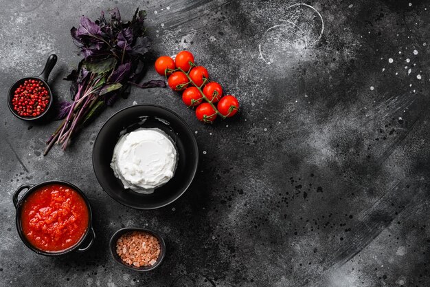 Ensemble de fromage ricotta, sur fond de table en pierre noire foncée, vue de dessus à plat, avec espace de copie pour le texte