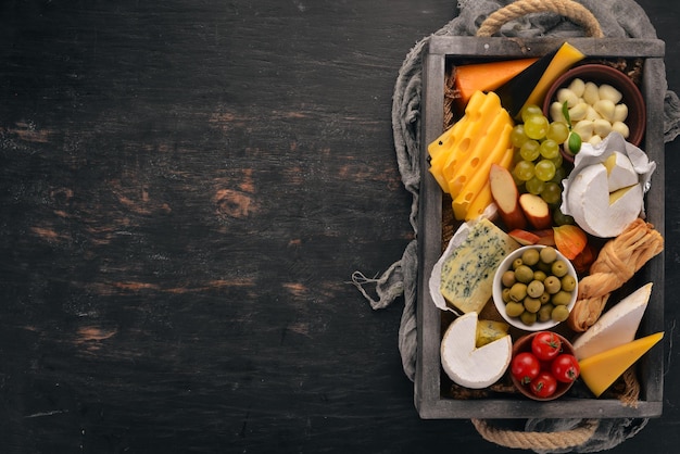 Un ensemble de fromages dans une boîte en bois Parmesan Mamasam Mozzarella Brie Feta Vue de dessus Sur un fond en bois Espace libre pour votre texte