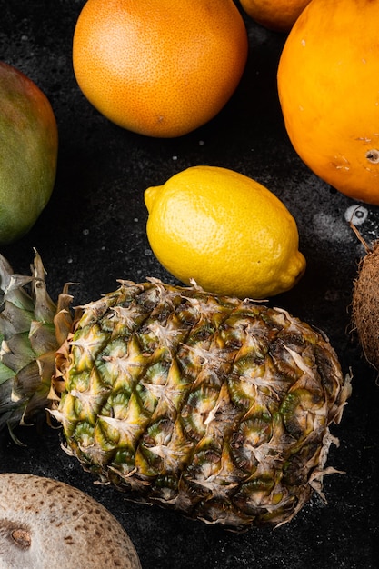 Ensemble de fruits tropicaux frais juteux mûrs, sur fond de table en pierre noire noire, vue de dessus à plat