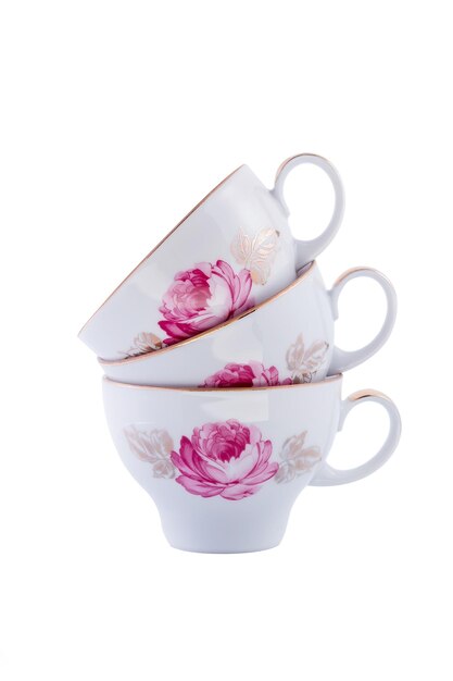 Ensemble en gros plan de belles tasses à thé en porcelaine vintage blanc cobalt avec motif floral sur fond blanc. Espace de copie.