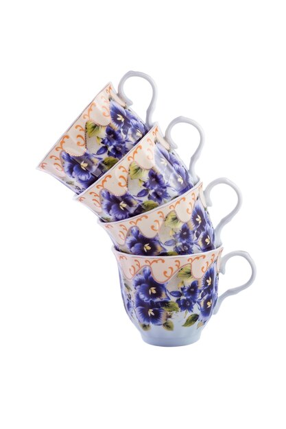 Ensemble en gros plan de belles tasses à thé en porcelaine vintage blanc cobalt avec motif floral sur fond blanc. Espace de copie.