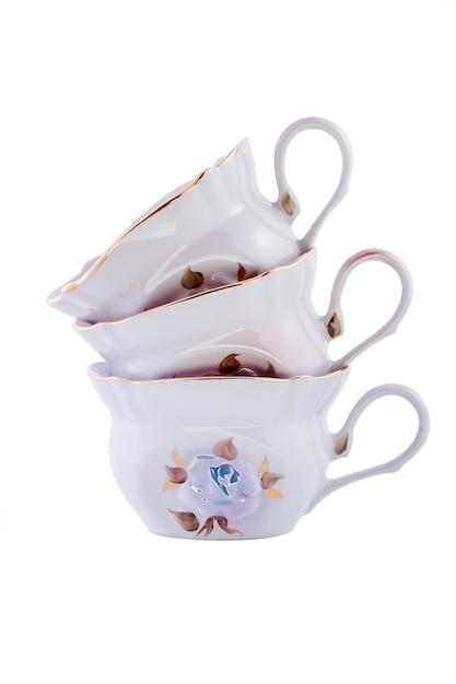 Ensemble en gros plan de belles tasses à thé en porcelaine vintage blanc cobalt avec motif floral sur fond blanc