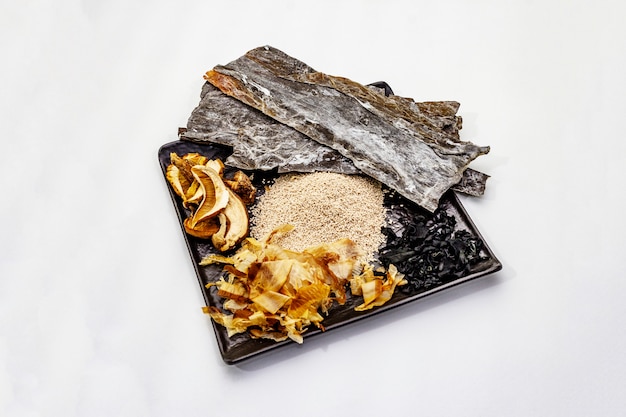 Ensemble d'ingrédient japonais traditionnel pour la cuisson du bouillon dashi de base. Algues kombu et wakame, katsuobushi et champignons secs. Isolé