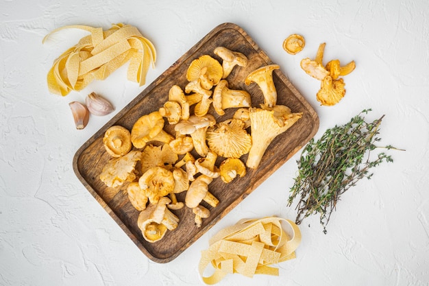 Ensemble d'ingrédients de champignons girolles de pâtes, sur fond de table en pierre blanche, vue de dessus à plat