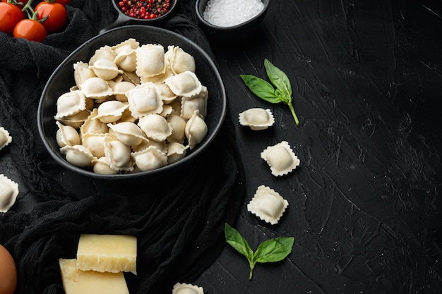 Ensemble d'ingrédients raviolis crus, sur fond noir