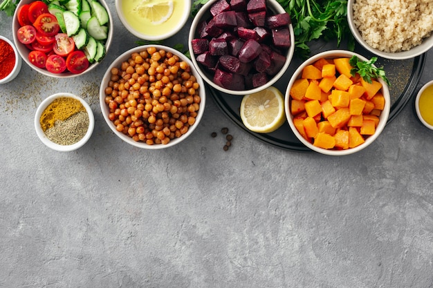 Ensemble d'ingrédients végétariens sains pour la cuisson. Pois chiches aux épices, potiron et betterave au four, quinoa et légumes.